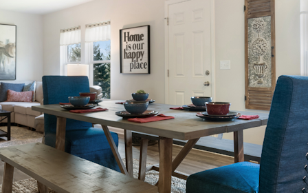 A living room with a table and chairs.