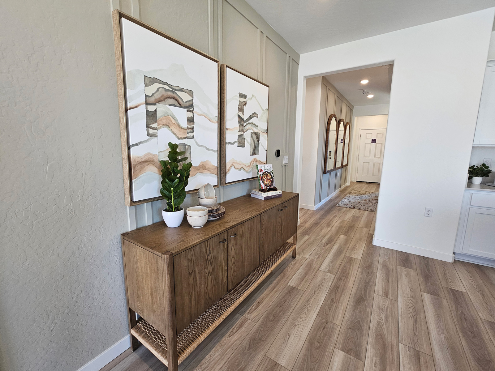 A room with a wood floor and a wood cabinet with a painting on it.