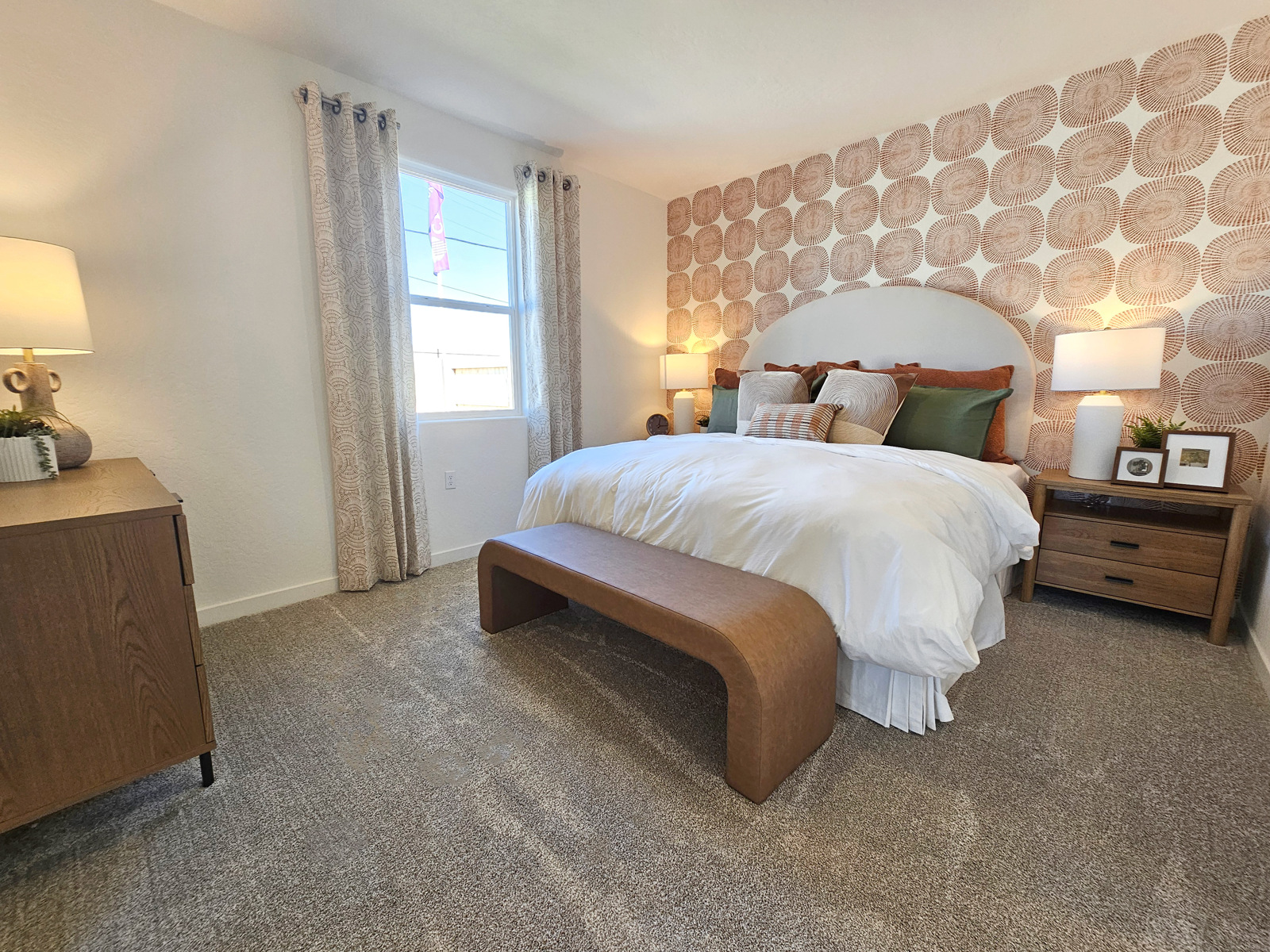 A bedroom with a bed and lamps.