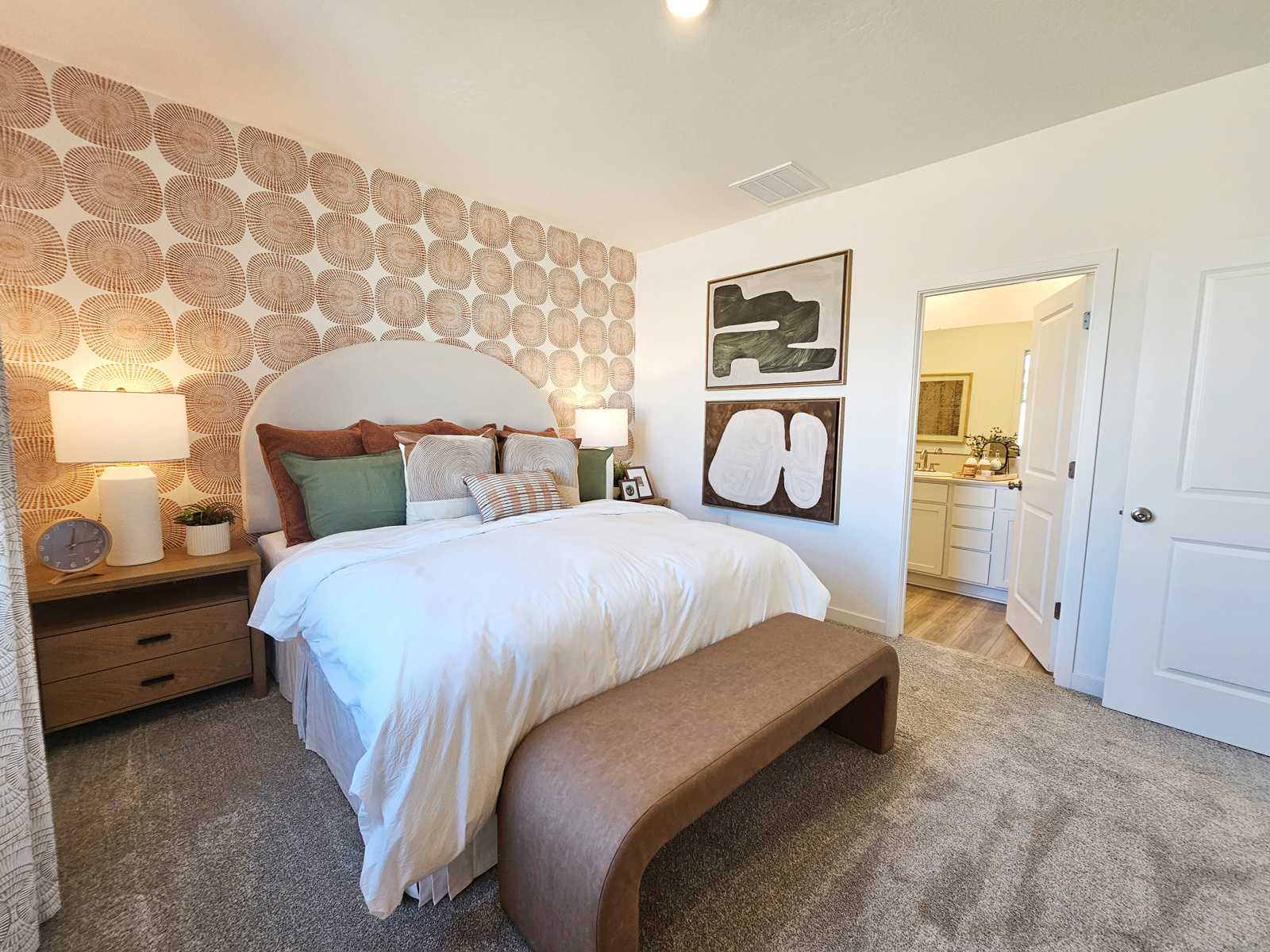 A bedroom with a bed and lamps.