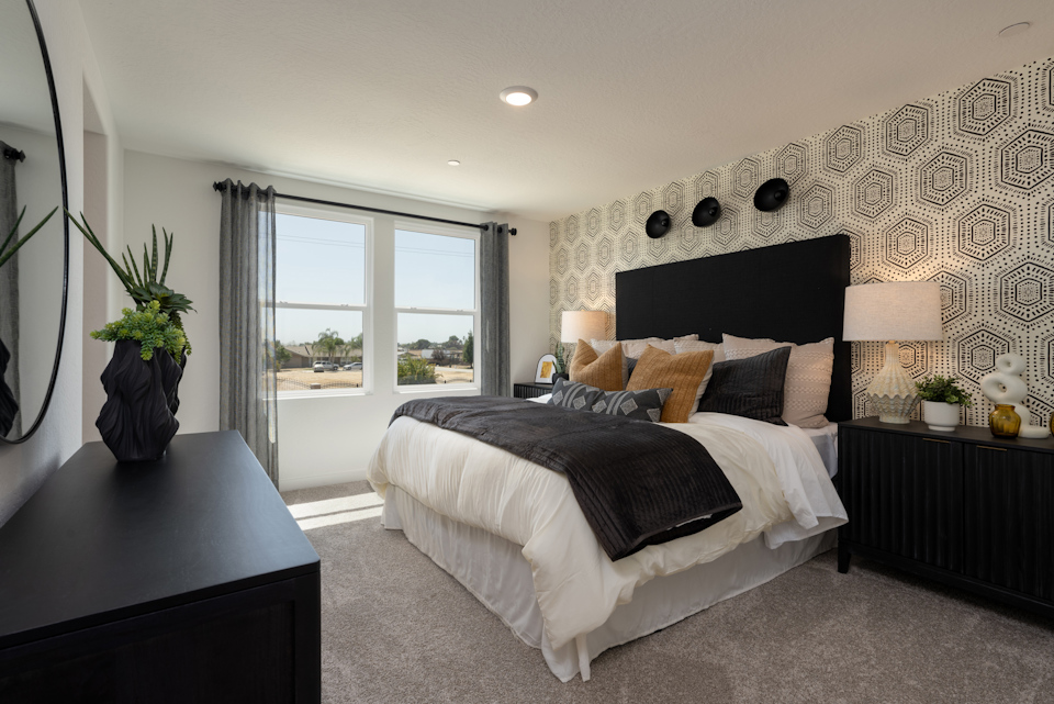 A bedroom with a bed and a desk.