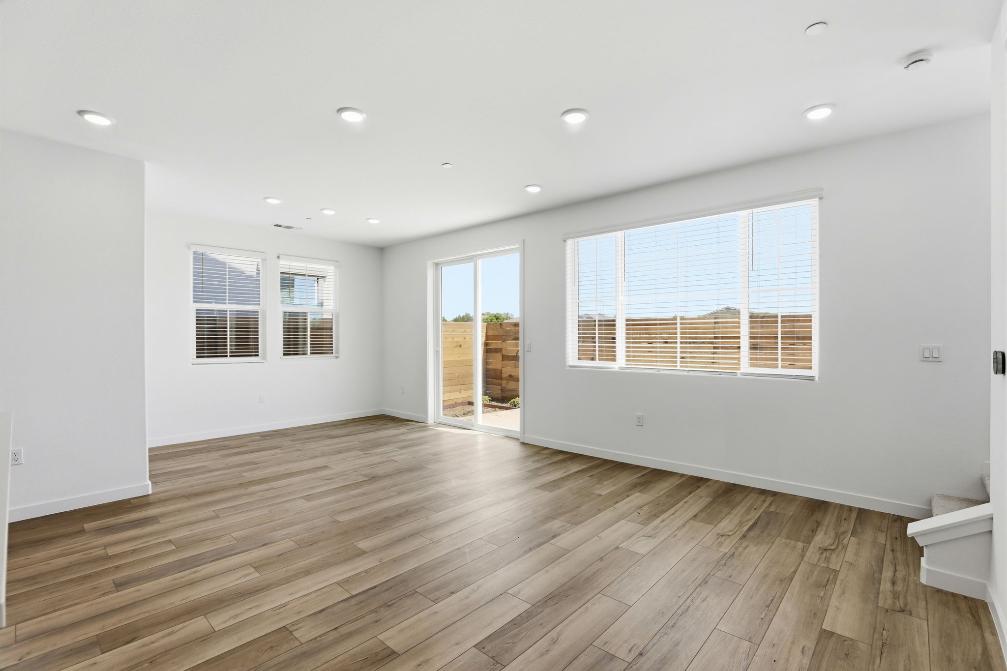 A room with a wood floor and windows.
