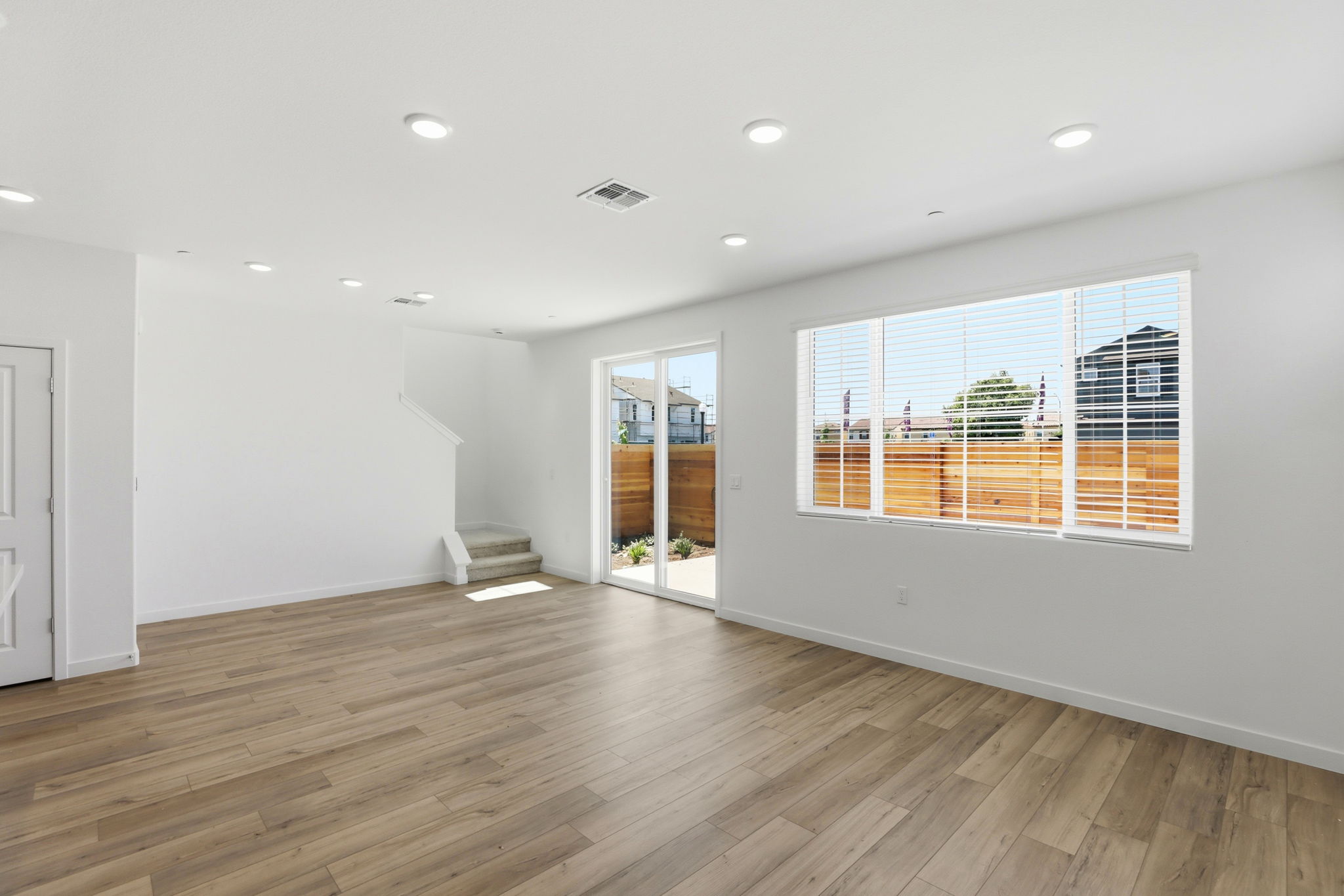 A room with a wood floor and windows.