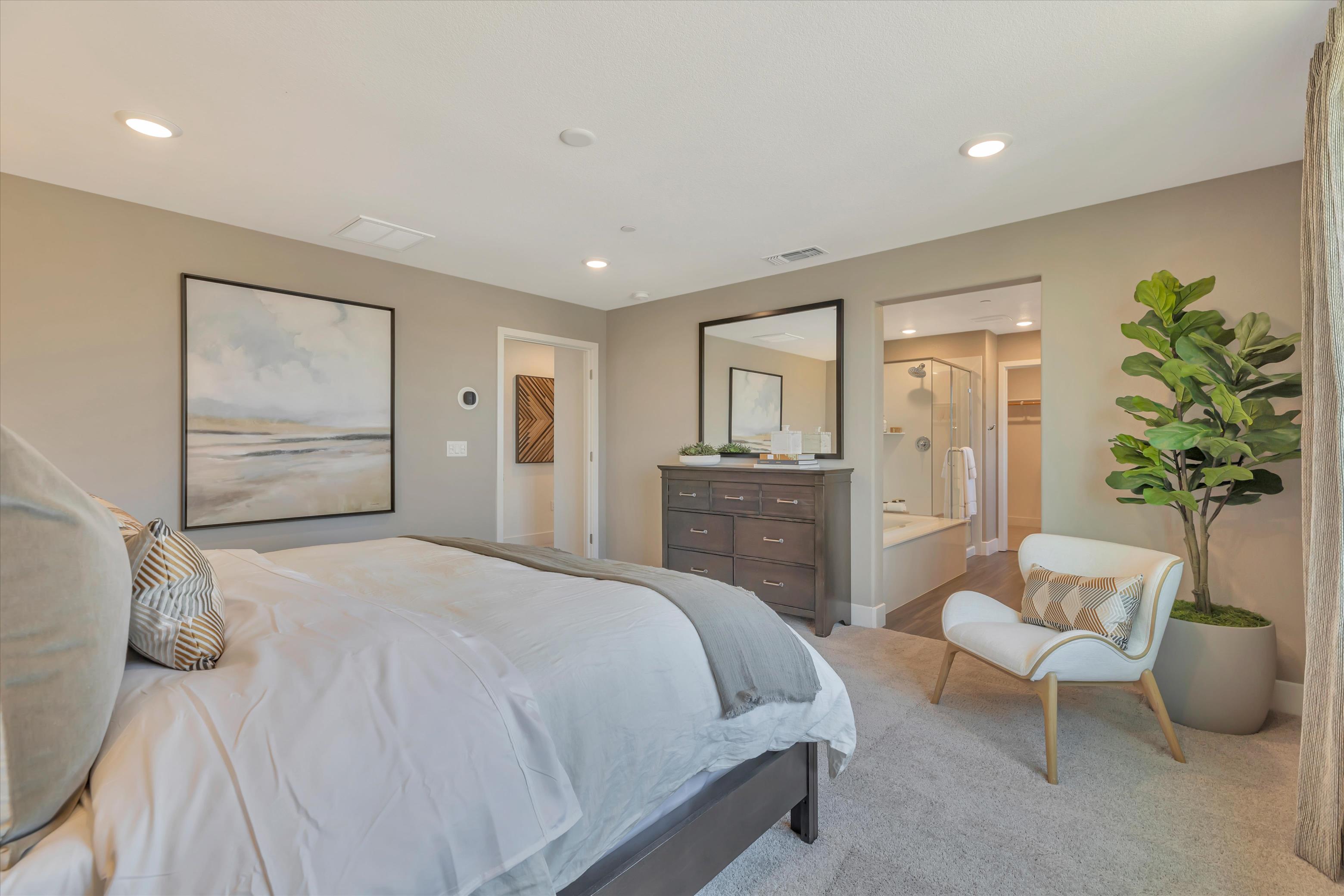 A bedroom with a bed and a chair.