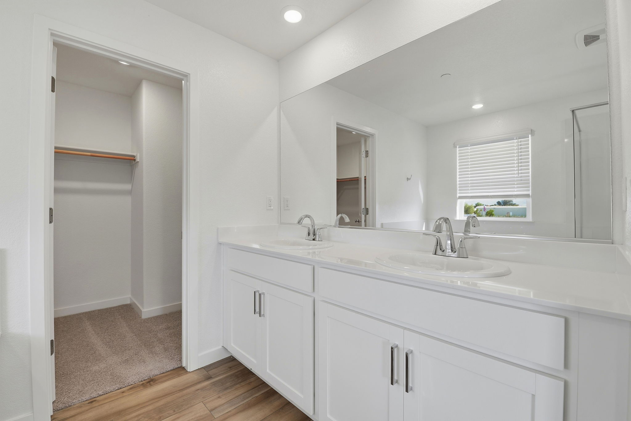 A bathroom with white cabinets.