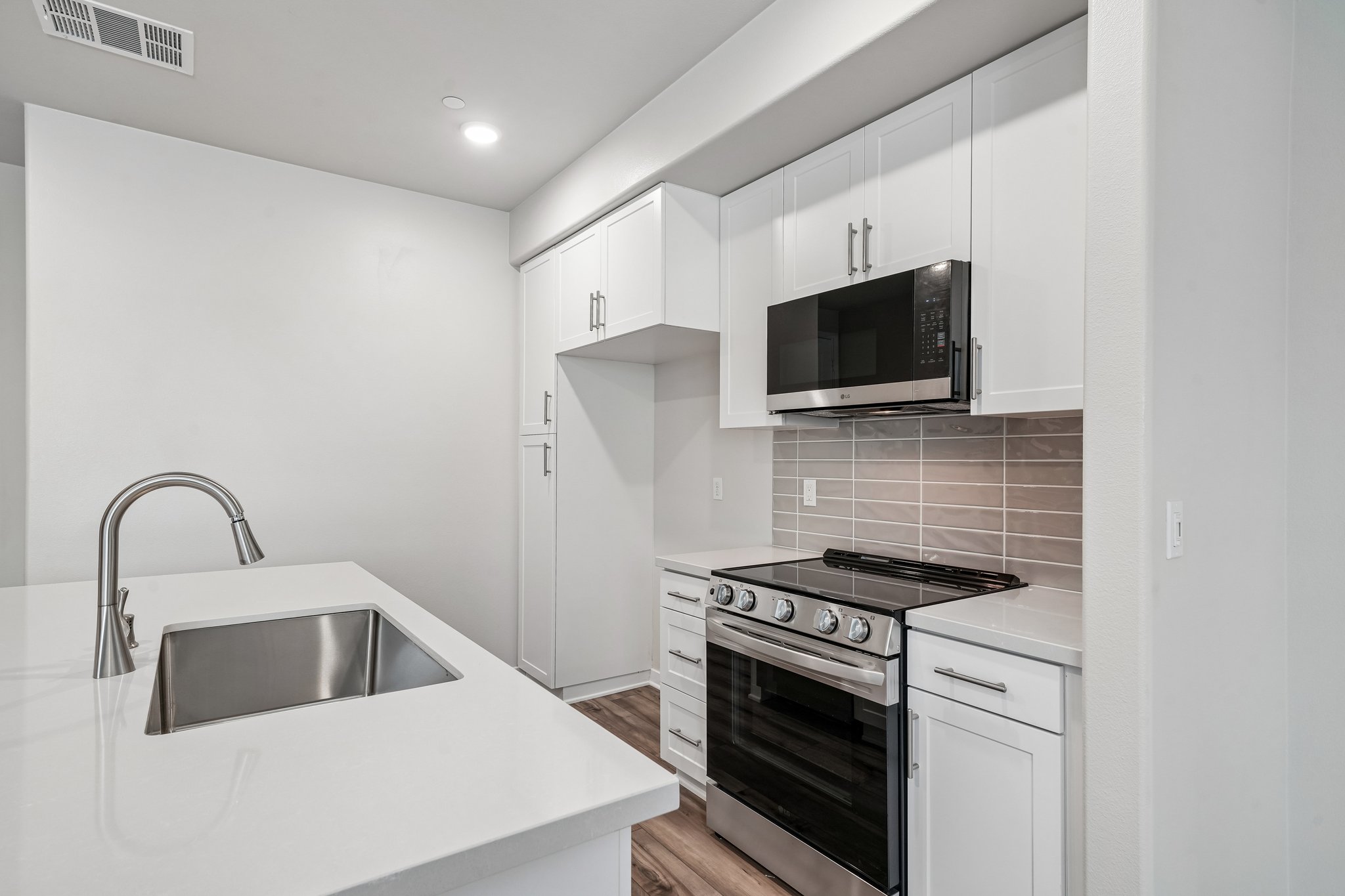 A kitchen with white cabinets.