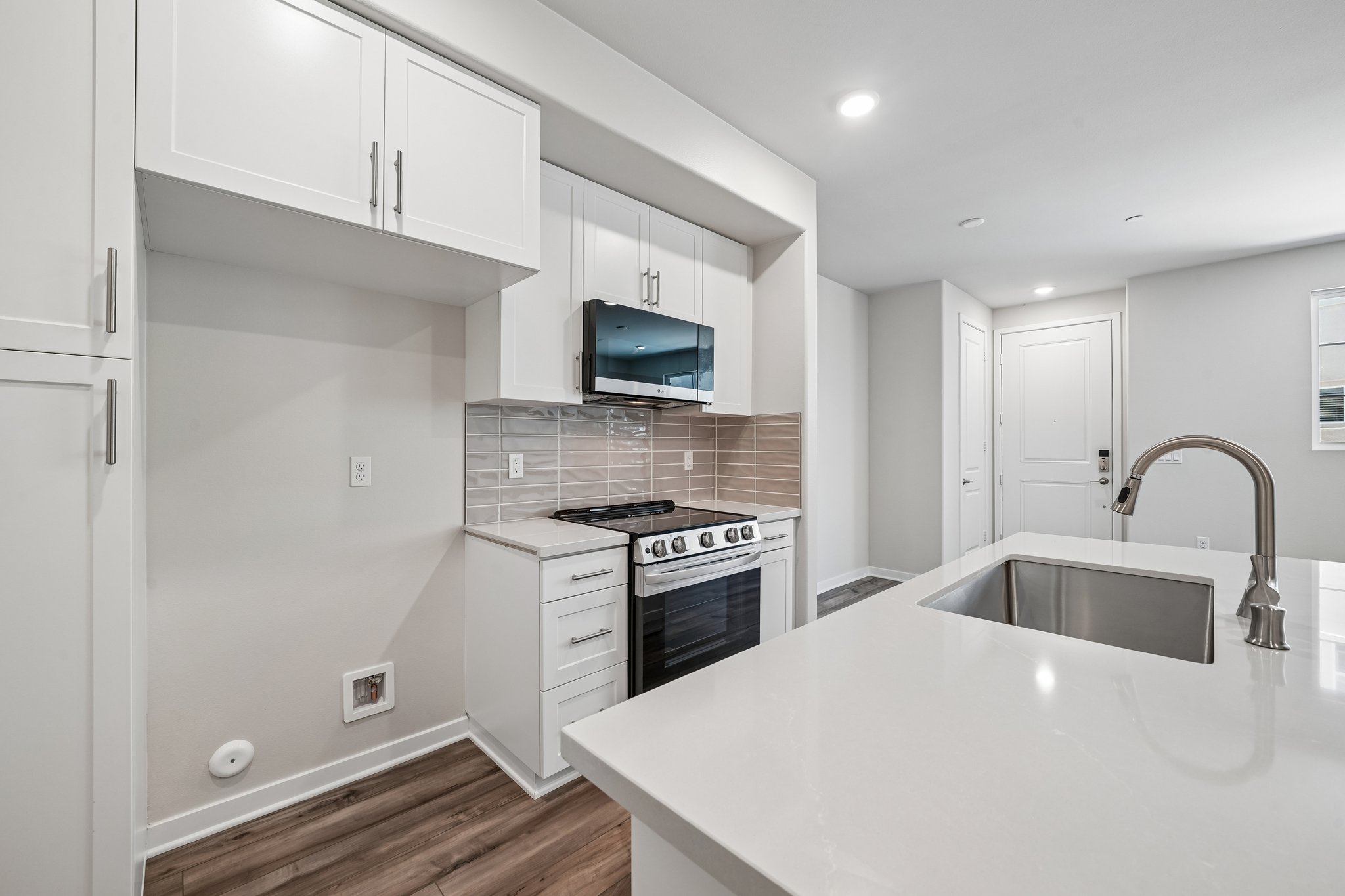 A kitchen with white cabinets.