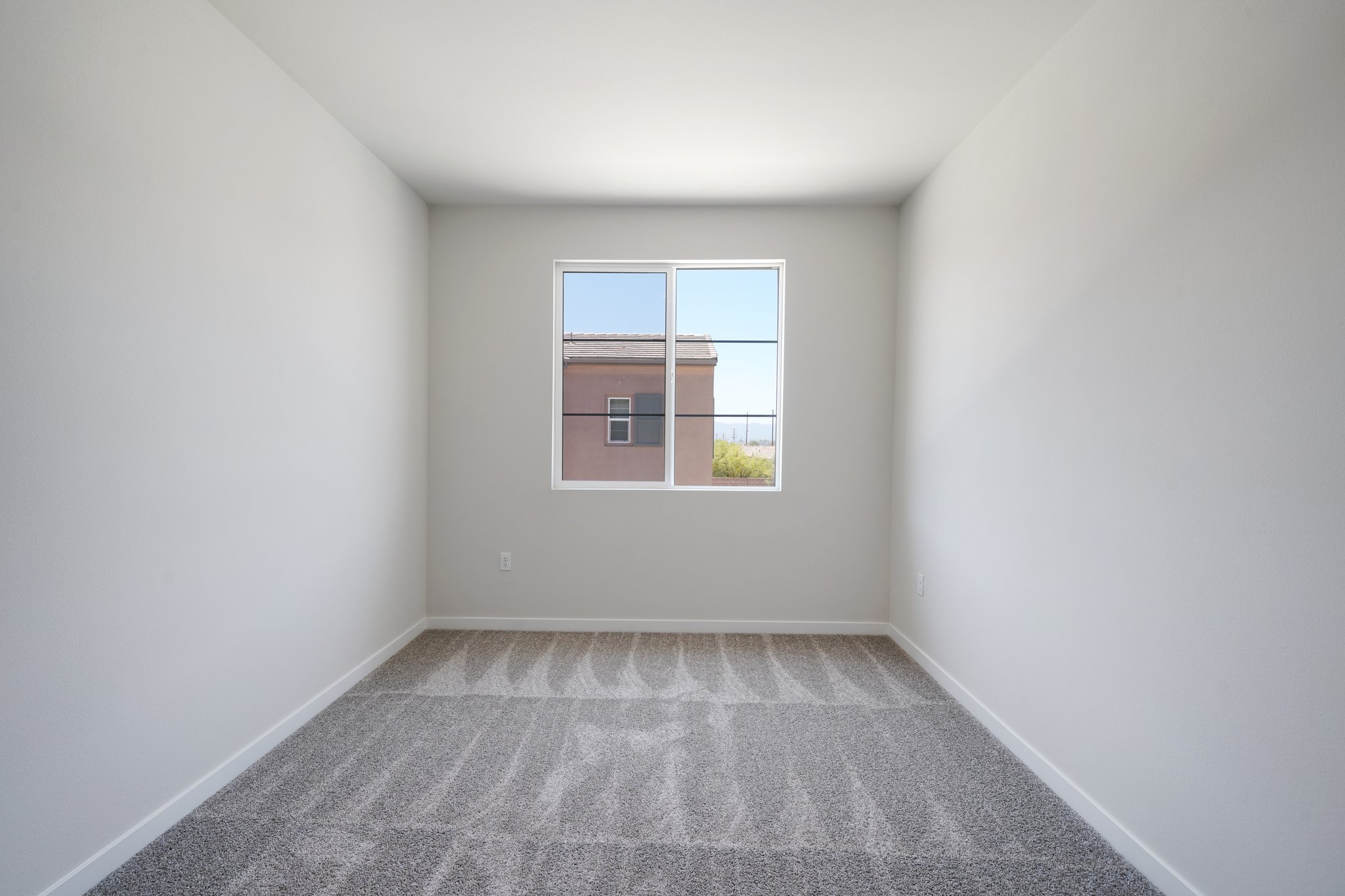 A room with a window and a carpet.