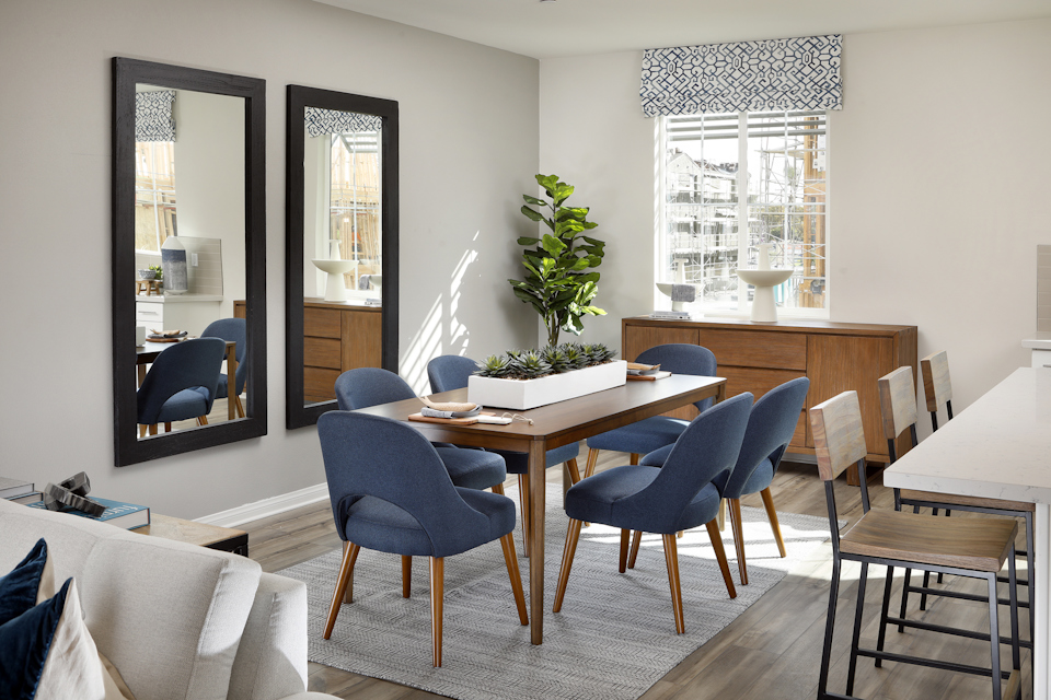 A room with a table chairs and a plant.