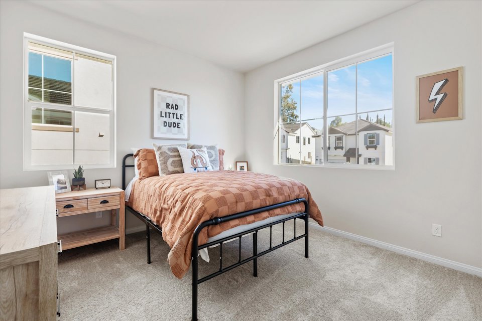 A bedroom with a bed and a bench.
