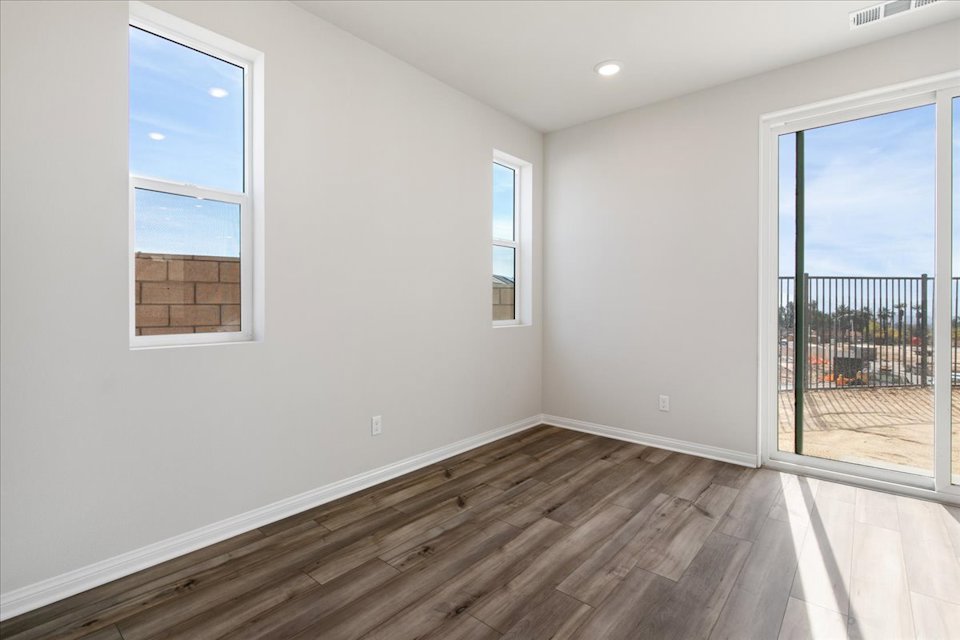 A room with a wood floor and windows.