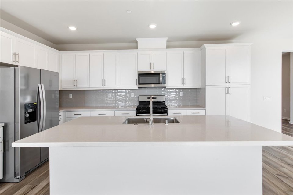 A kitchen with white cabinets.