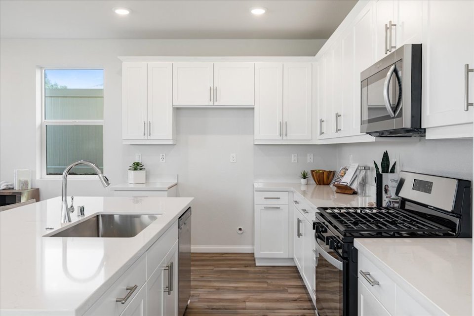 A kitchen with white cabinets.