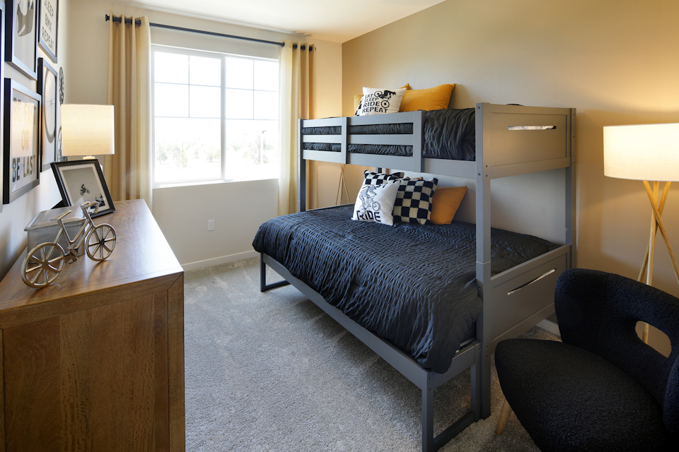 A bedroom with a desk and a bed.