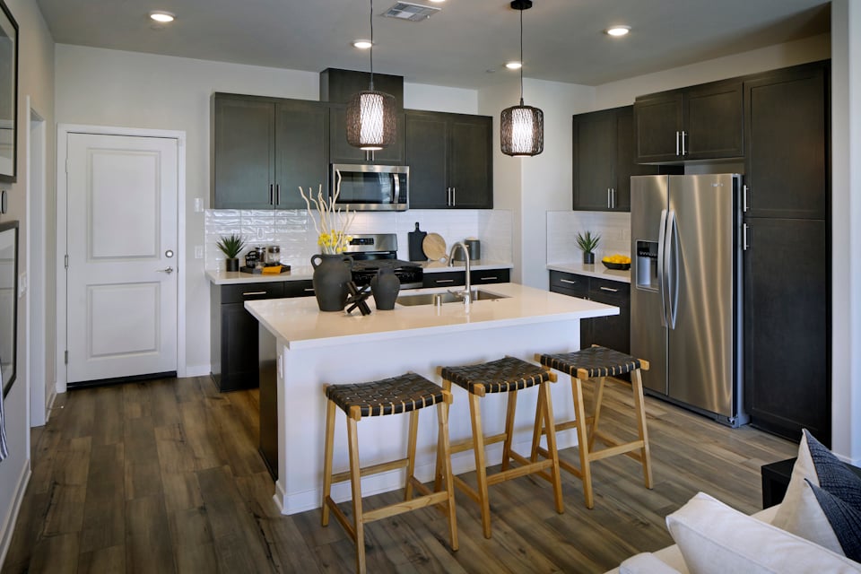 A kitchen with a bar and stools.