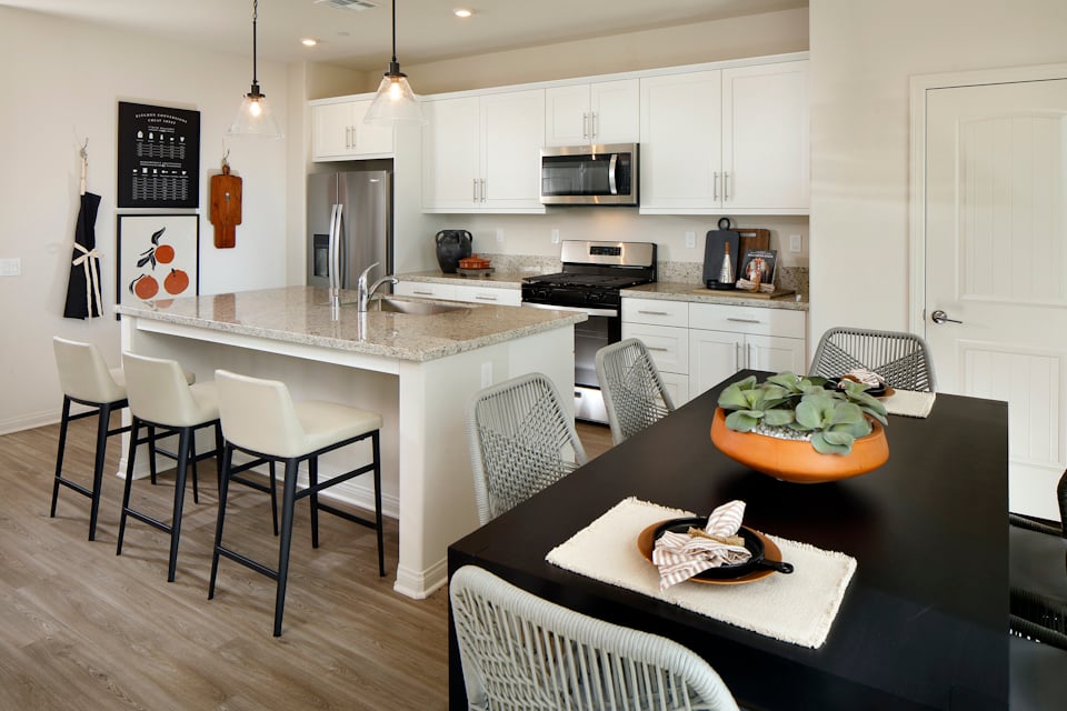 A kitchen with a table and chairs.