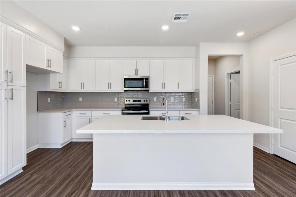 A kitchen with white cabinets.