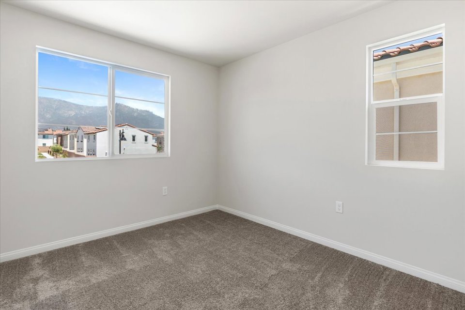 A room with a window and a rug in it.