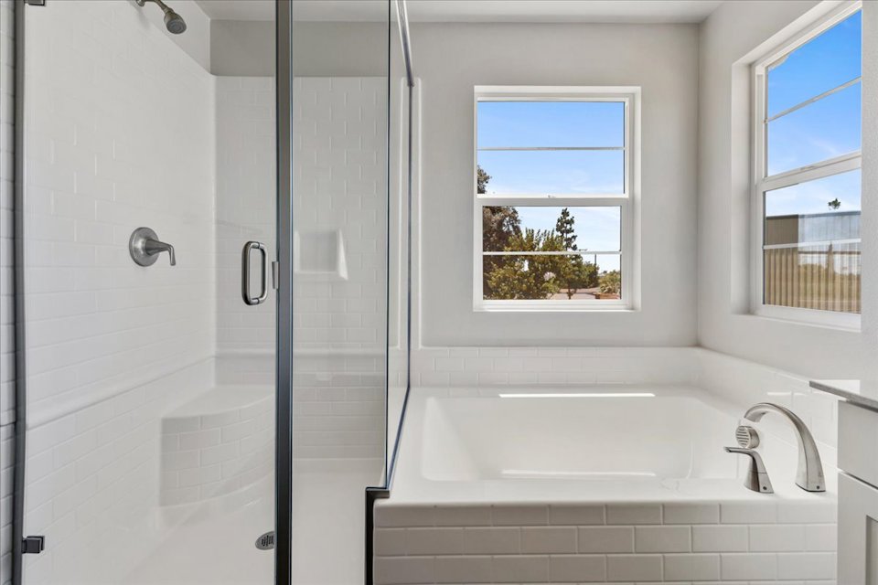 A bathroom with a tub and windows.