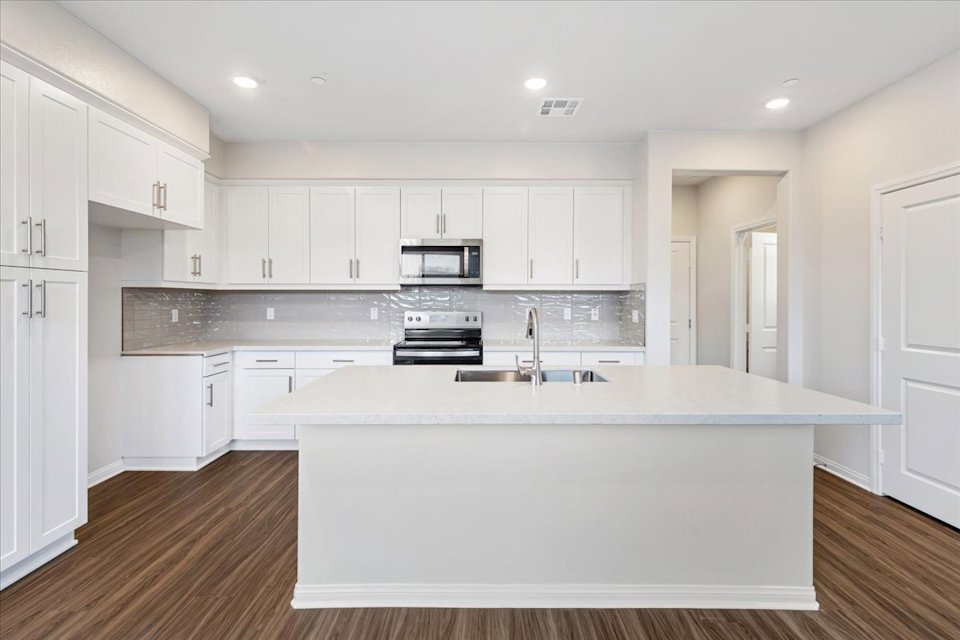 A kitchen with white cabinets.