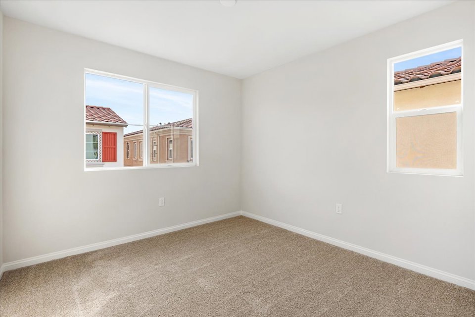 A room with a carpet and windows.