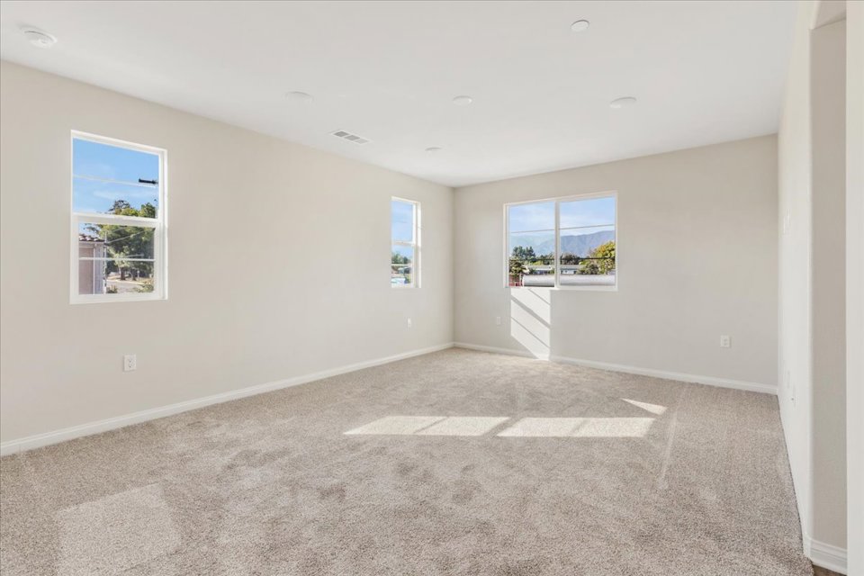 A room with a carpet and windows.