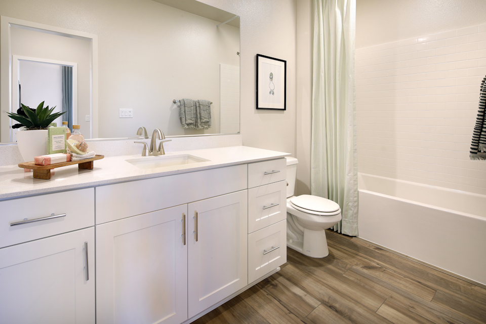 A bathroom with white cabinets.