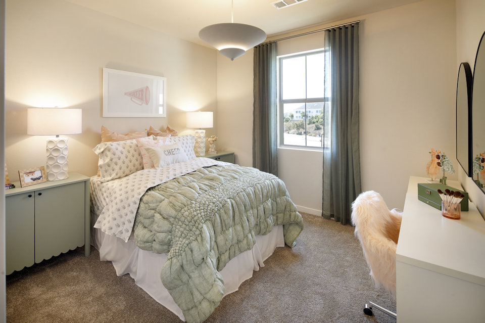 A bedroom with a bed and a chair.