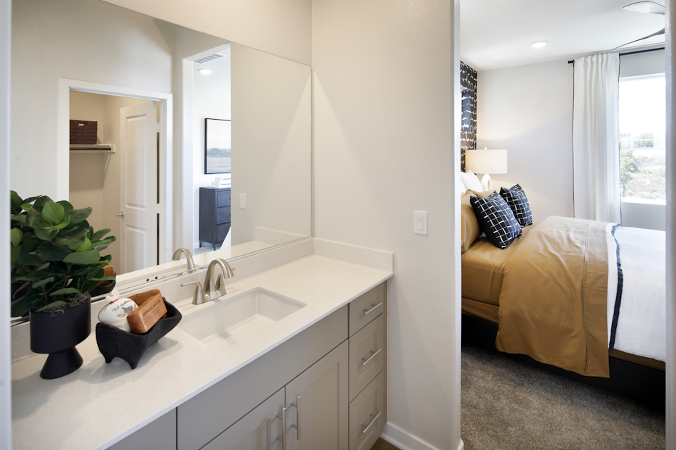 A bathroom with a bed and a sink.