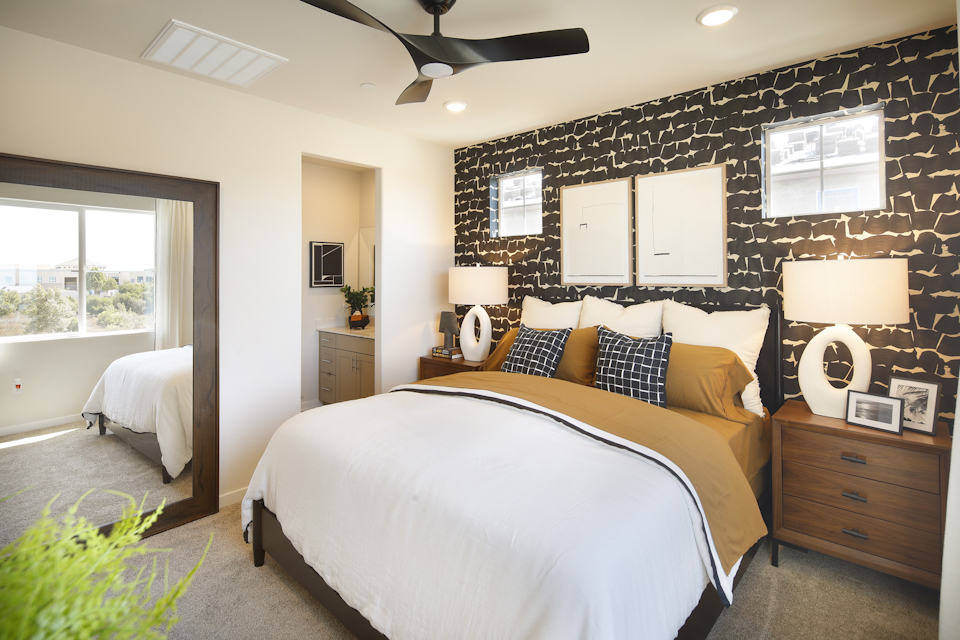 A bedroom with a bed and a fan.