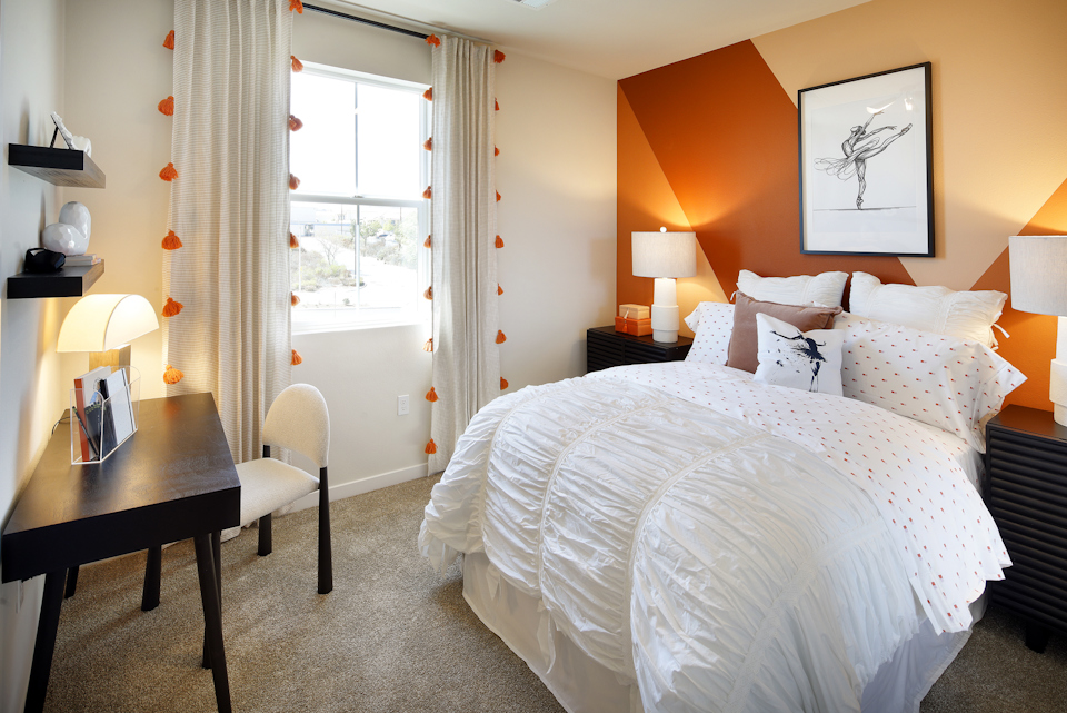 A bedroom with a bed and a desk.