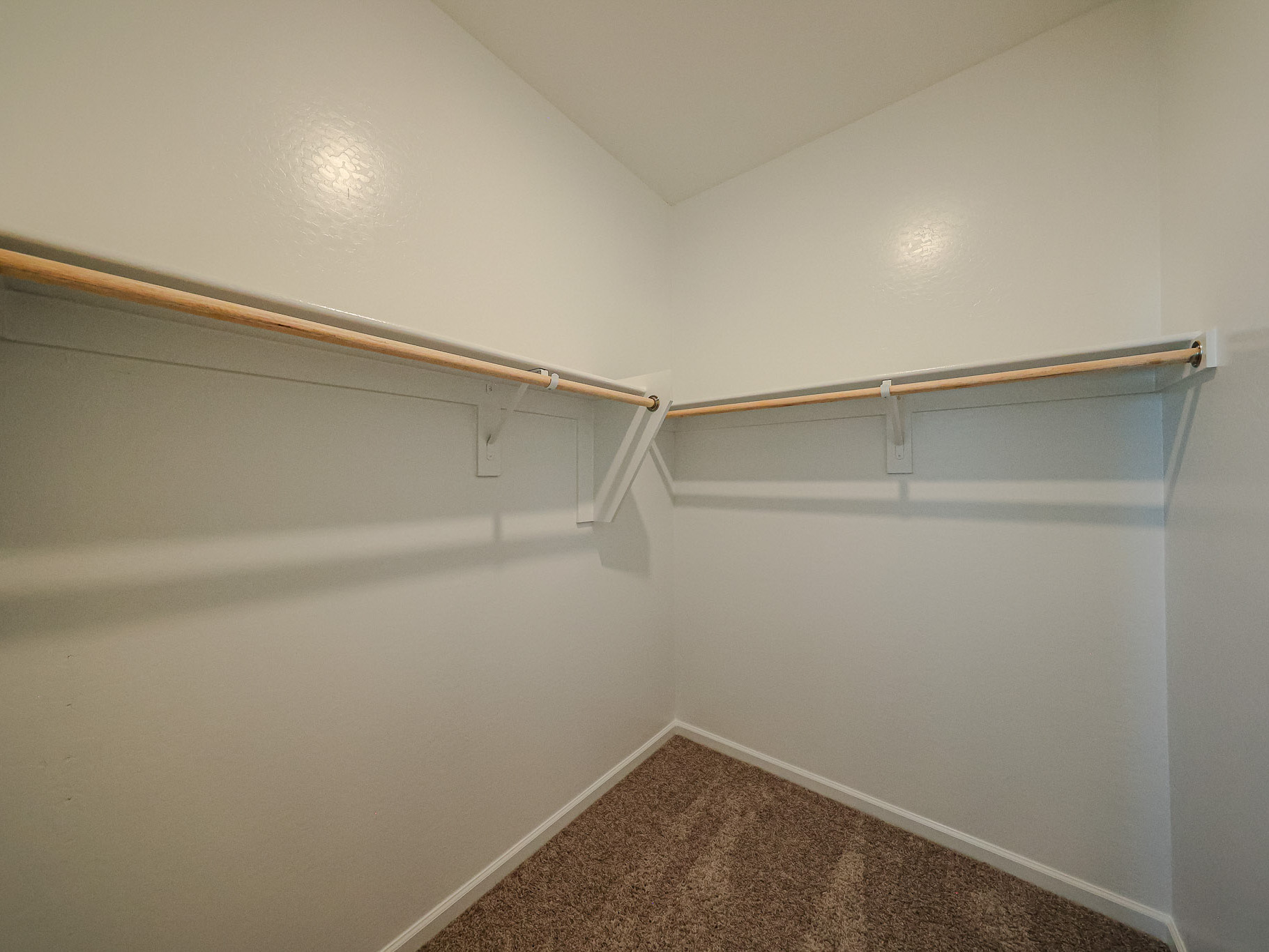 A white wall with a metal bar.