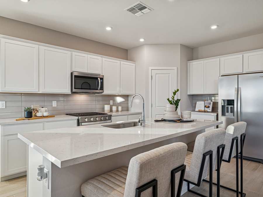 A kitchen with white cabinets.