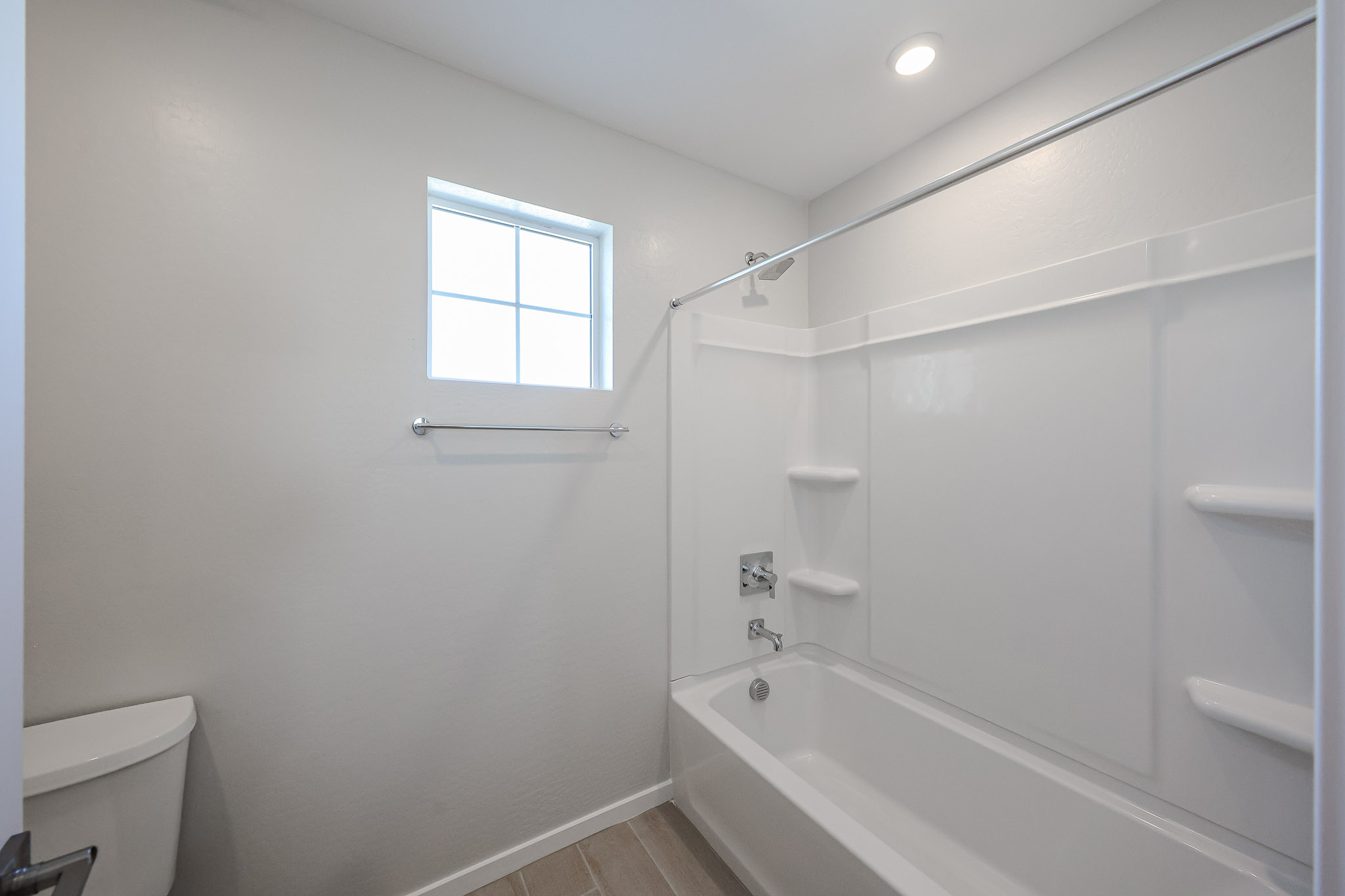 A bathroom with a tub and toilet.
