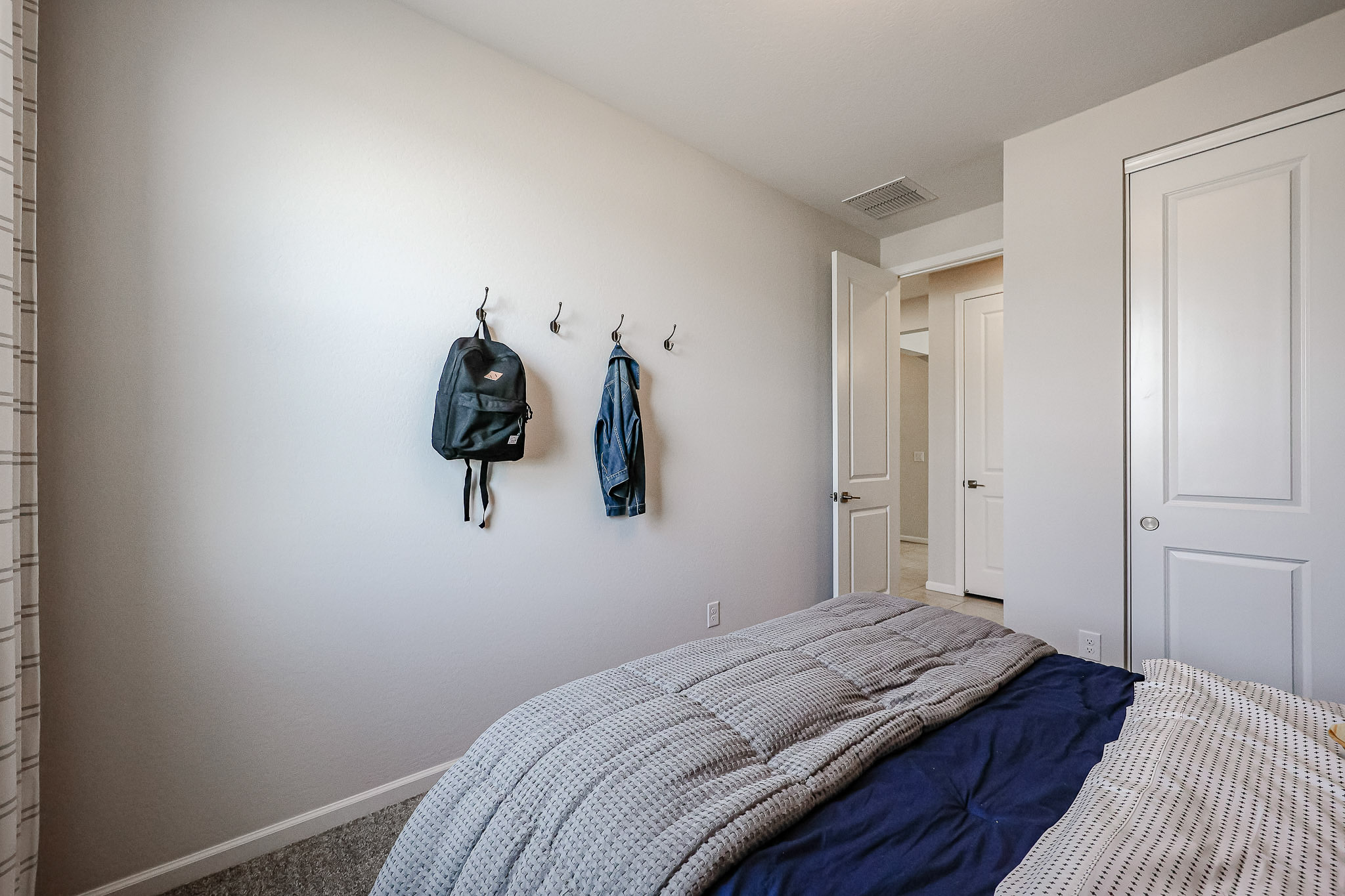 A bedroom with a bed and a blue blanket.