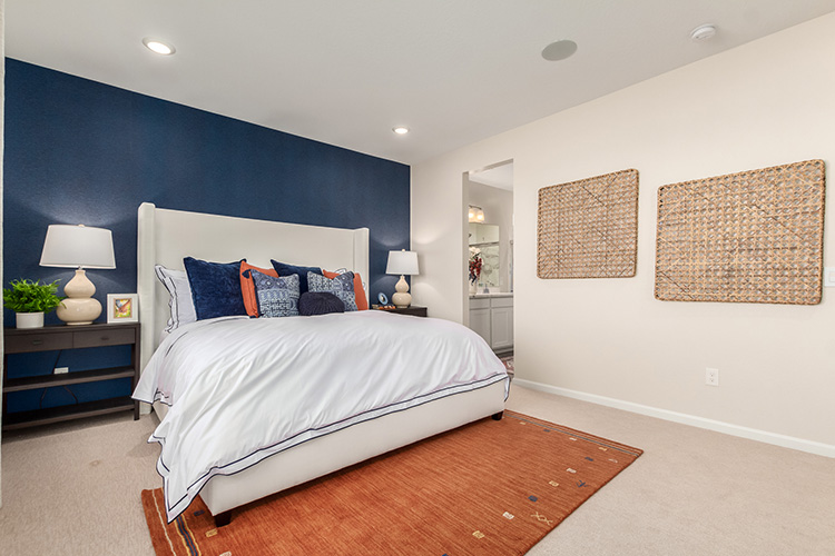 A bedroom with a bed and lamps.