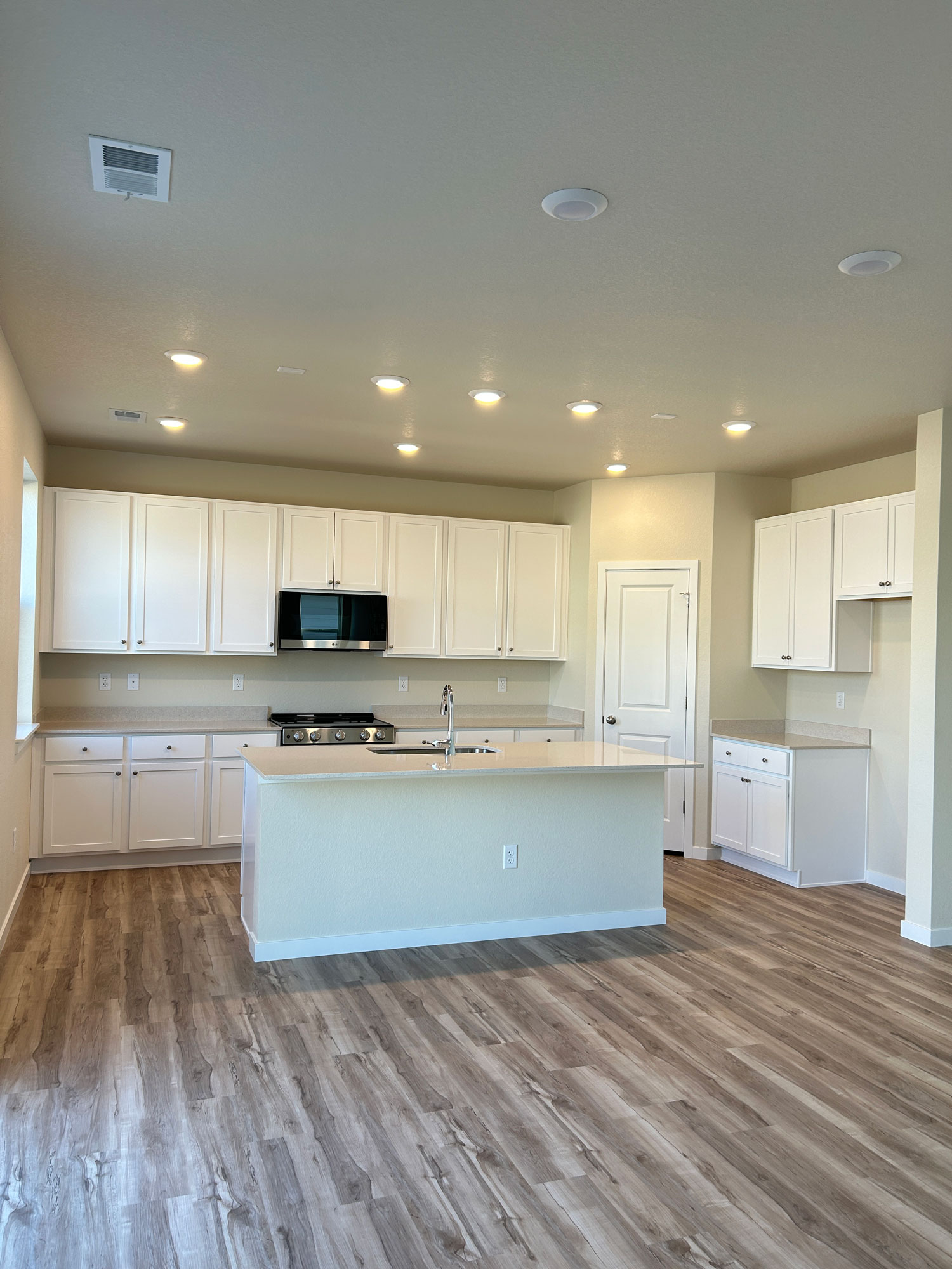 A kitchen with white cabinets.