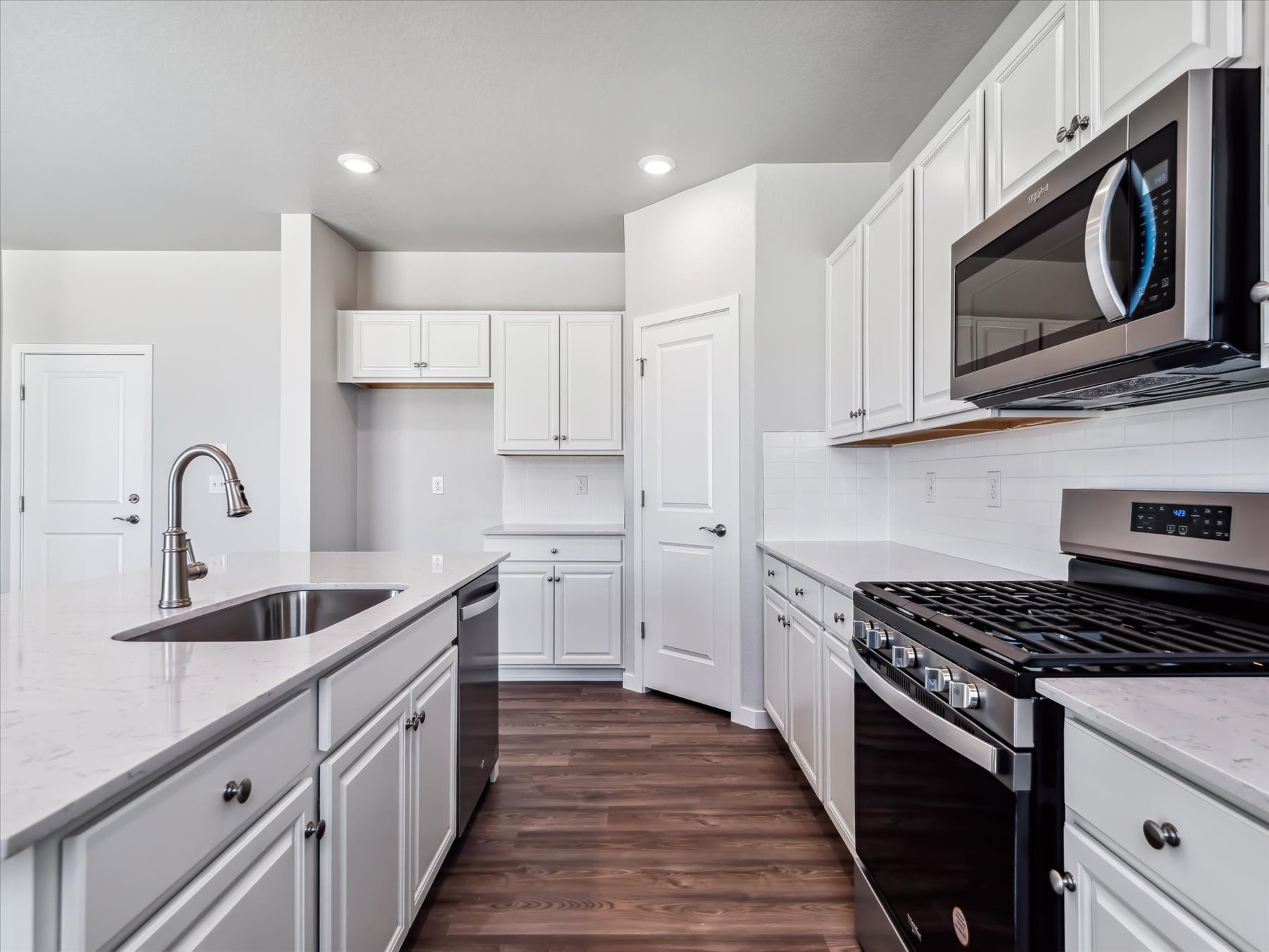 A kitchen with white cabinets.