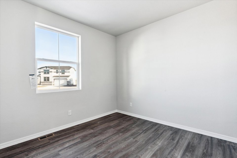 A room with a window and a wood floor.