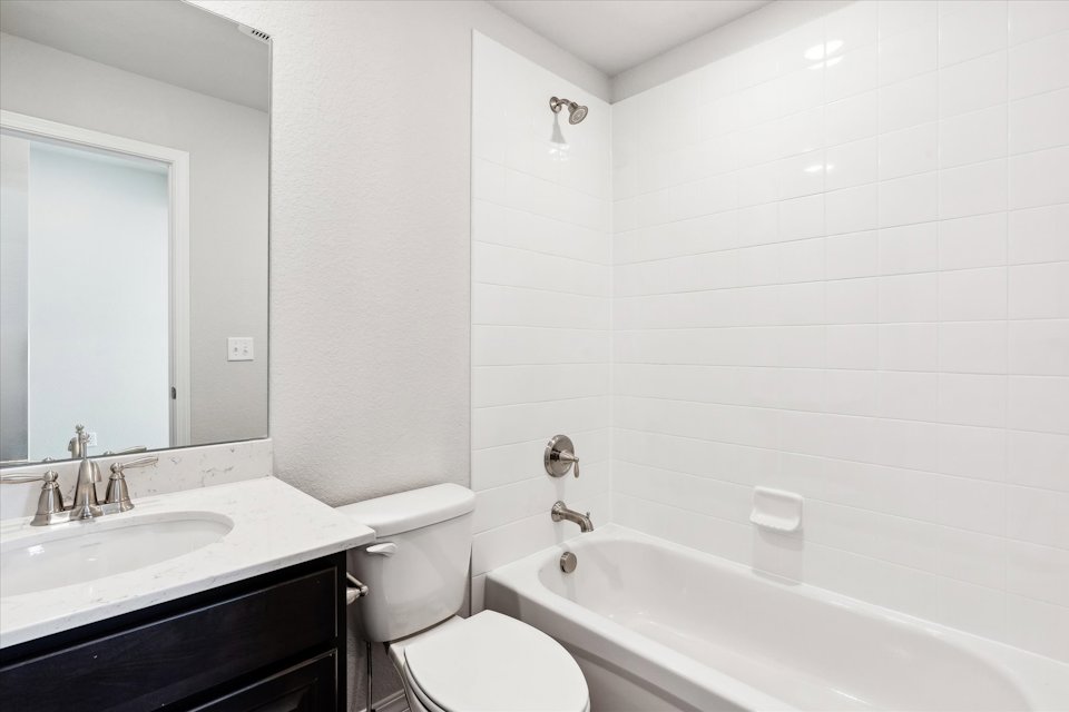 A bathroom with a tub sink and toilet.