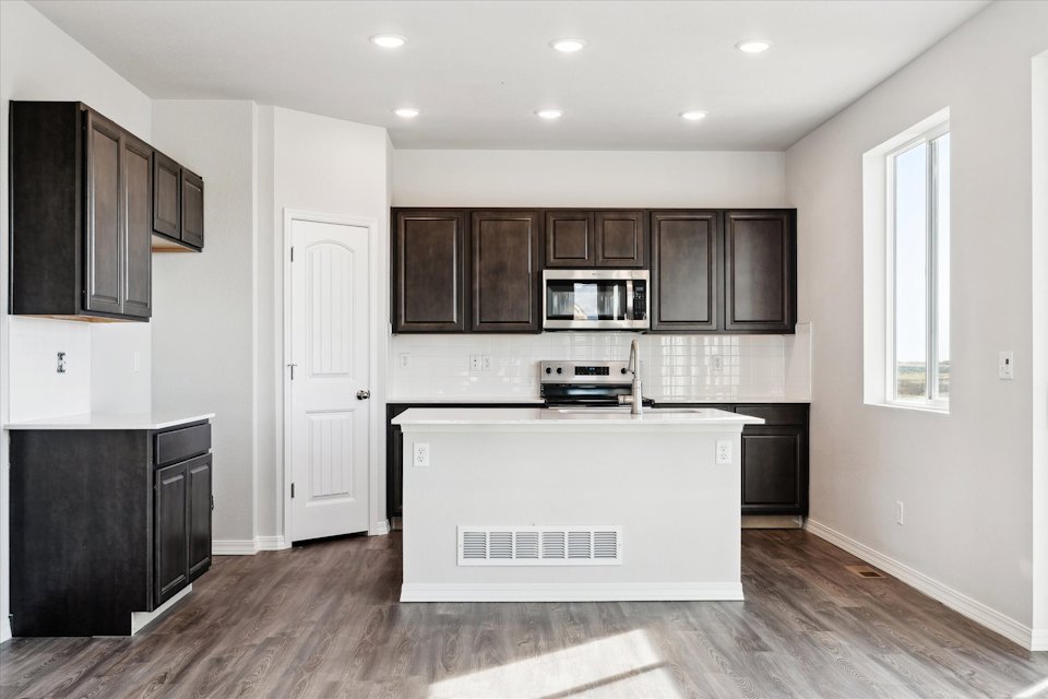 A kitchen with black cabinets.