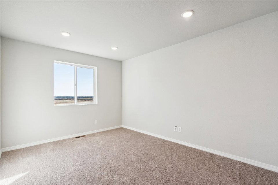 A room with a window and a carpet.