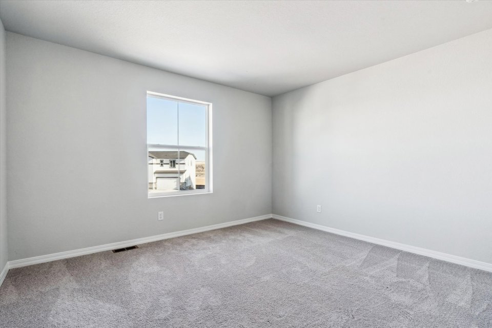 A room with a window and a carpet.