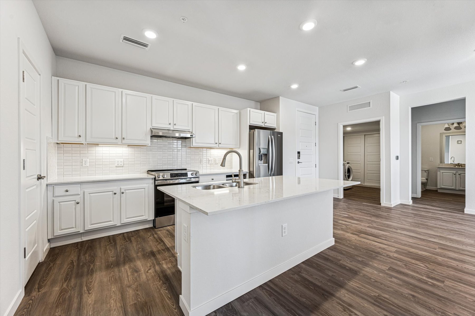 A kitchen with white cabinets.