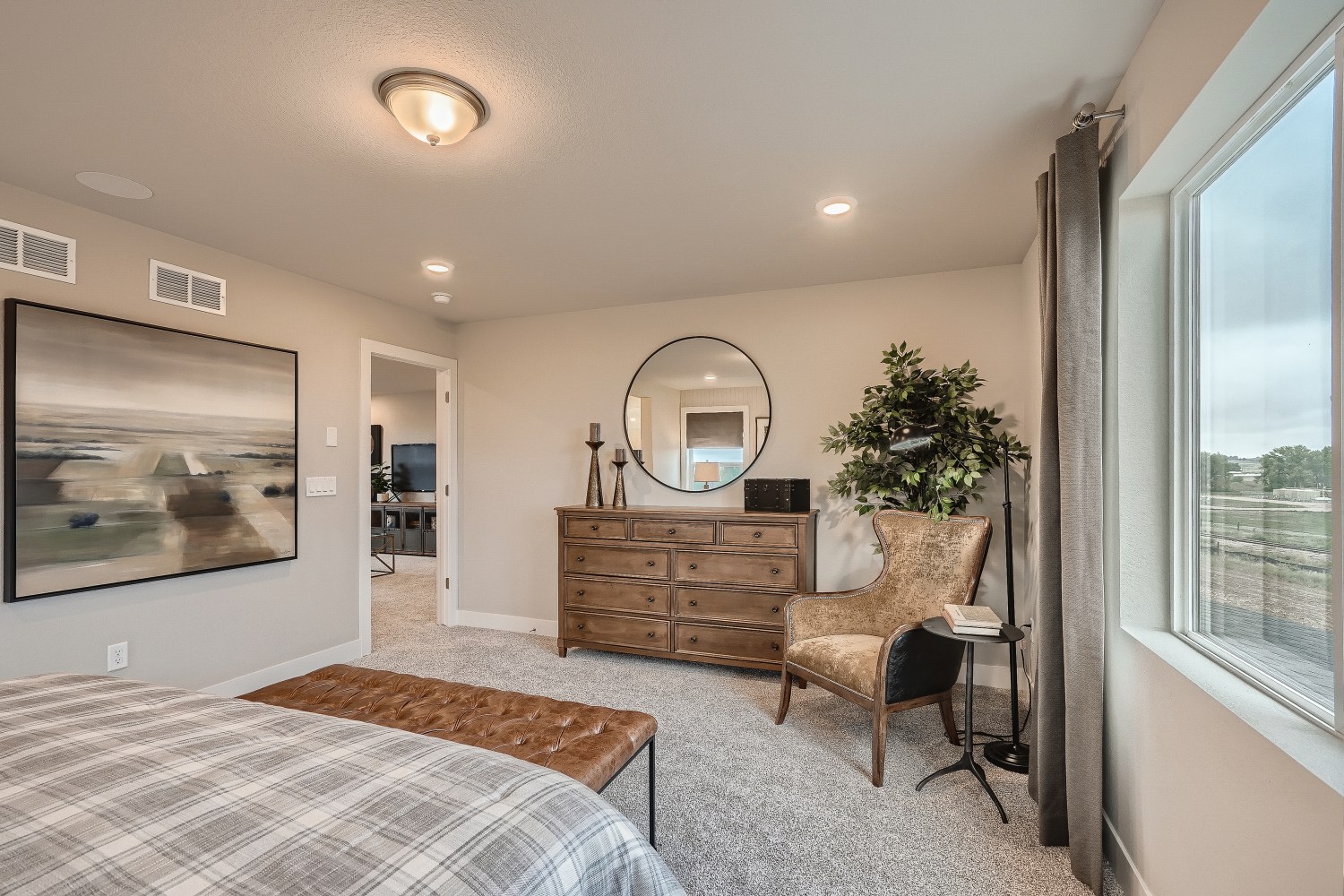 A bedroom with a bed and a chair.