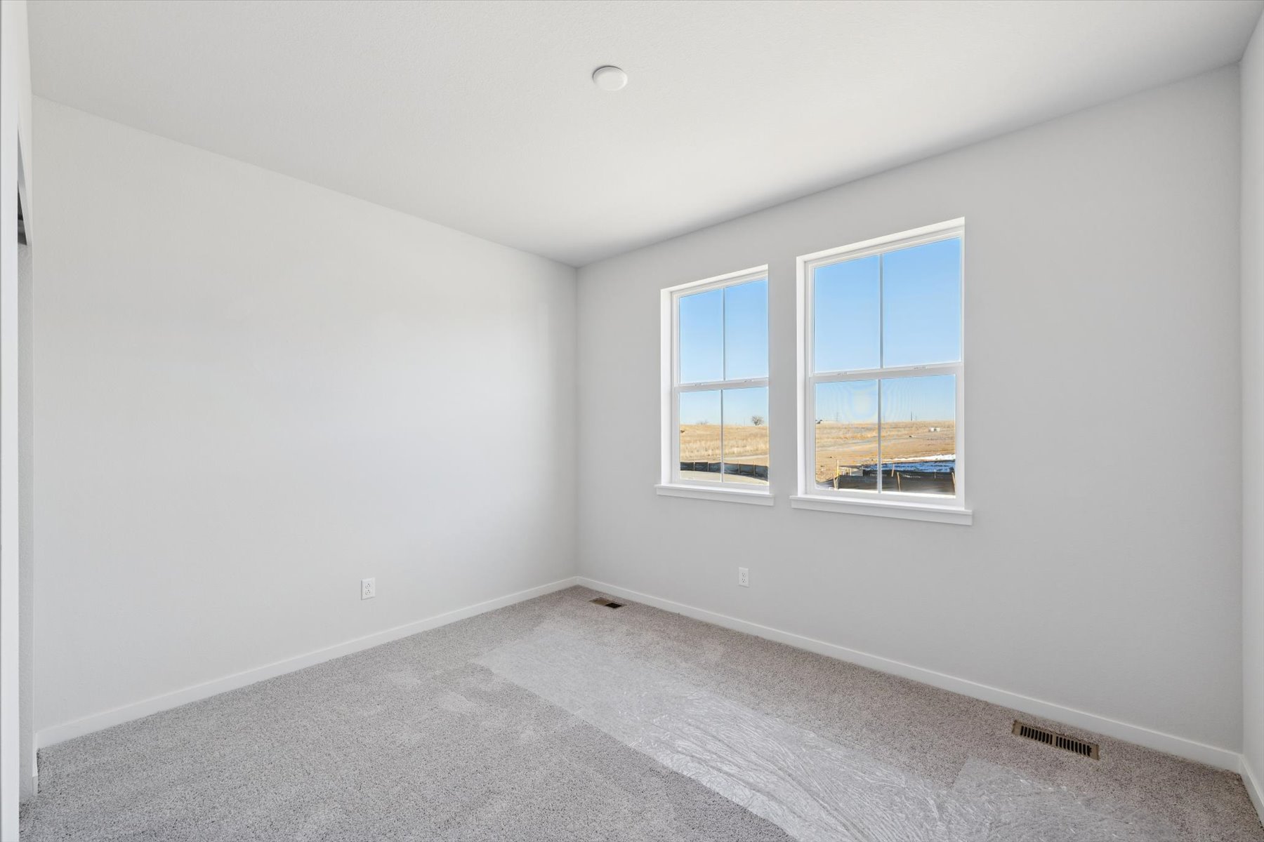 A room with a window and a carpet.