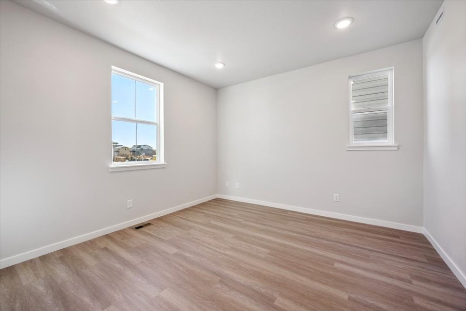 A room with a wood floor and a window with a wood floor.