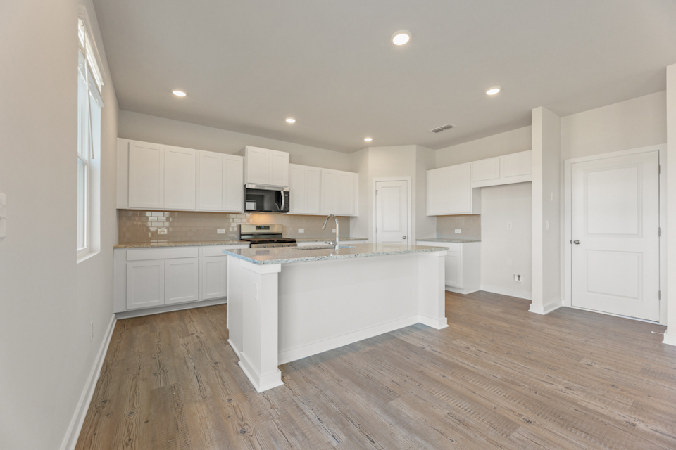 A kitchen with white cabinets.
