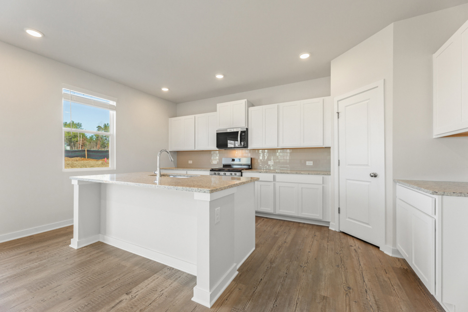 A kitchen with white cabinets.