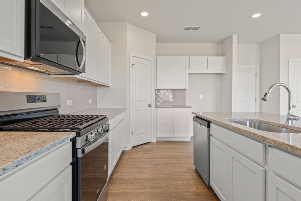 A kitchen with white cabinets.